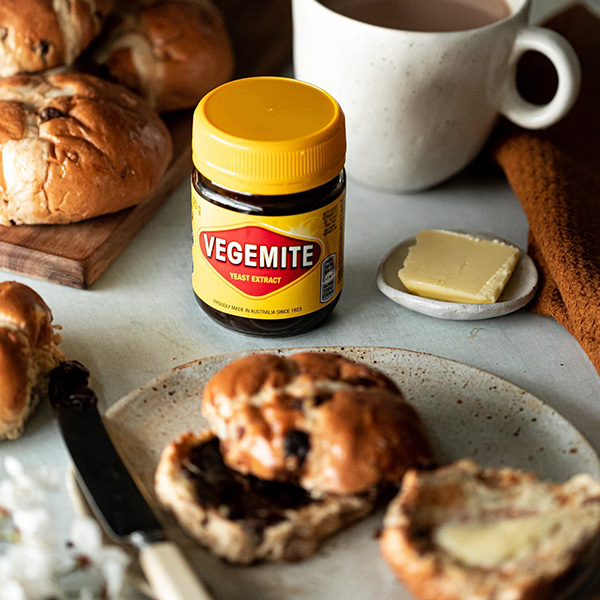 Photo of a jar of Vegemite beside some scones and butter